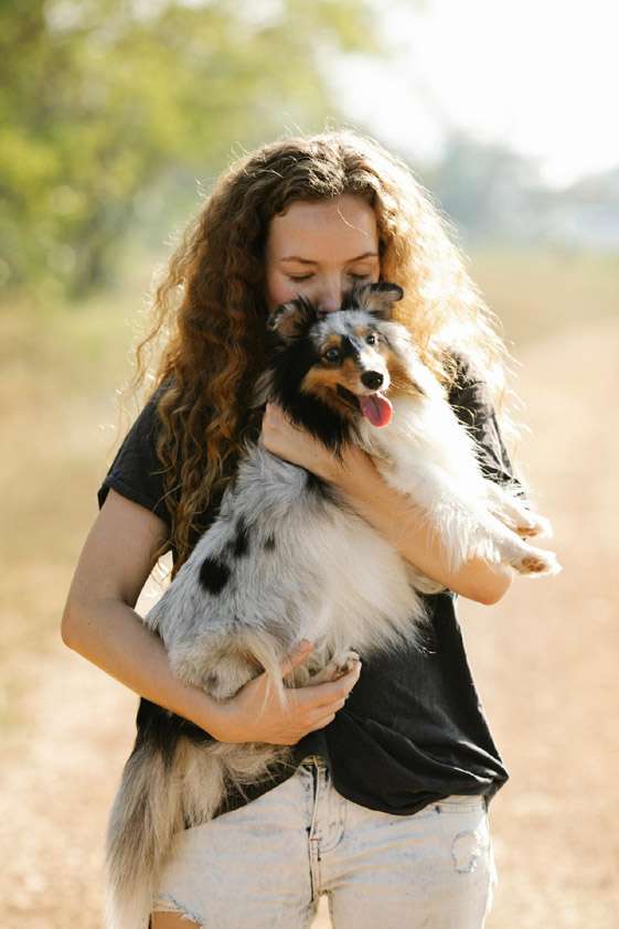 woman-holding-dog-by-pexels-blue-bird